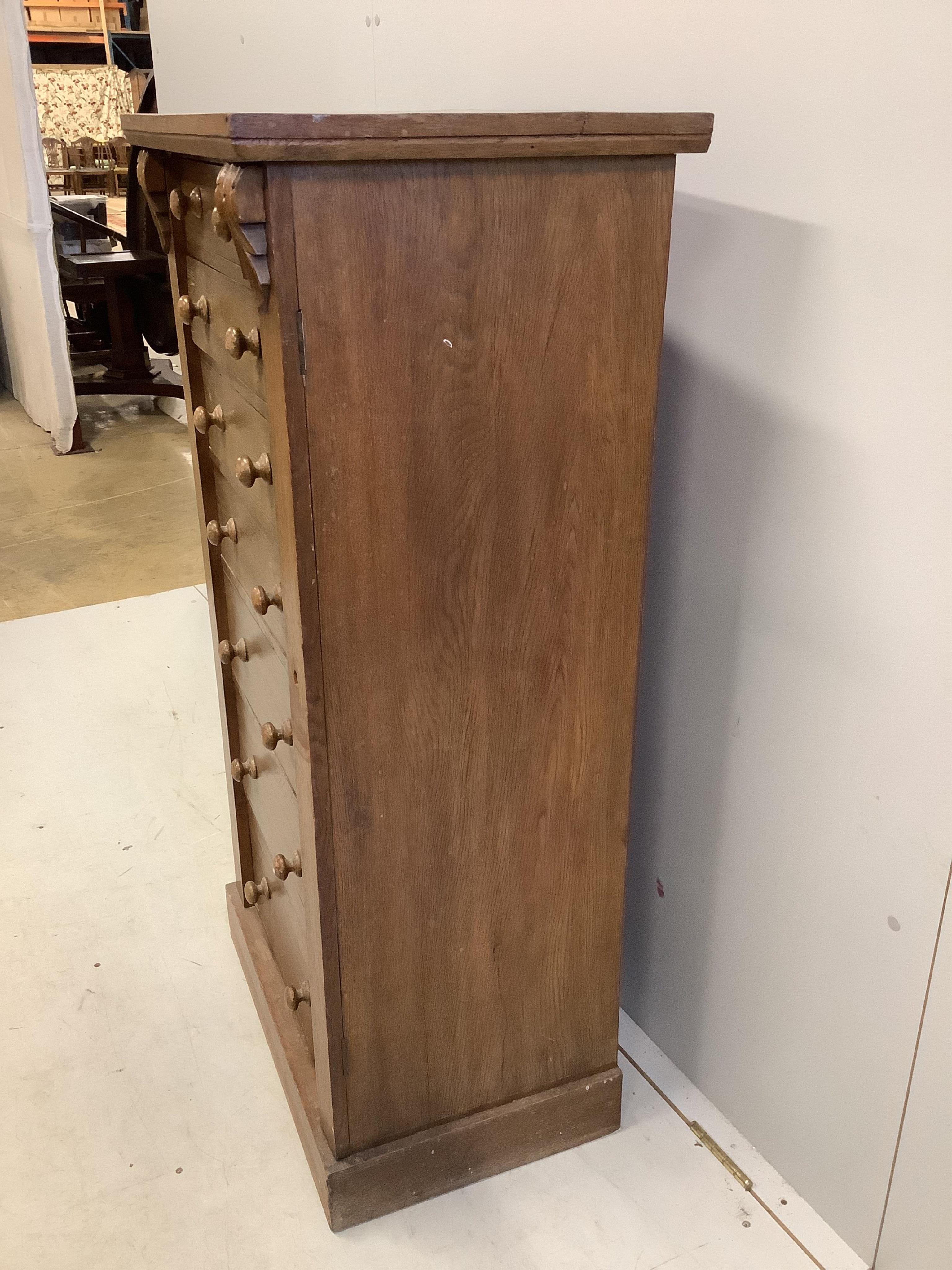 A Victorian style oak Wellington chest, width 60cm, depth 42cm, height 120cm. Condition - fair, top has a horizontal split, plinth foot scuffed and worn.